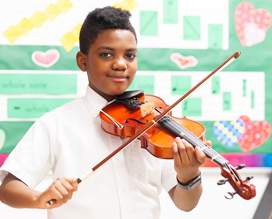 Student playing the violin in the music program