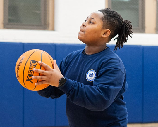 Student playing basketball in Gymnasium