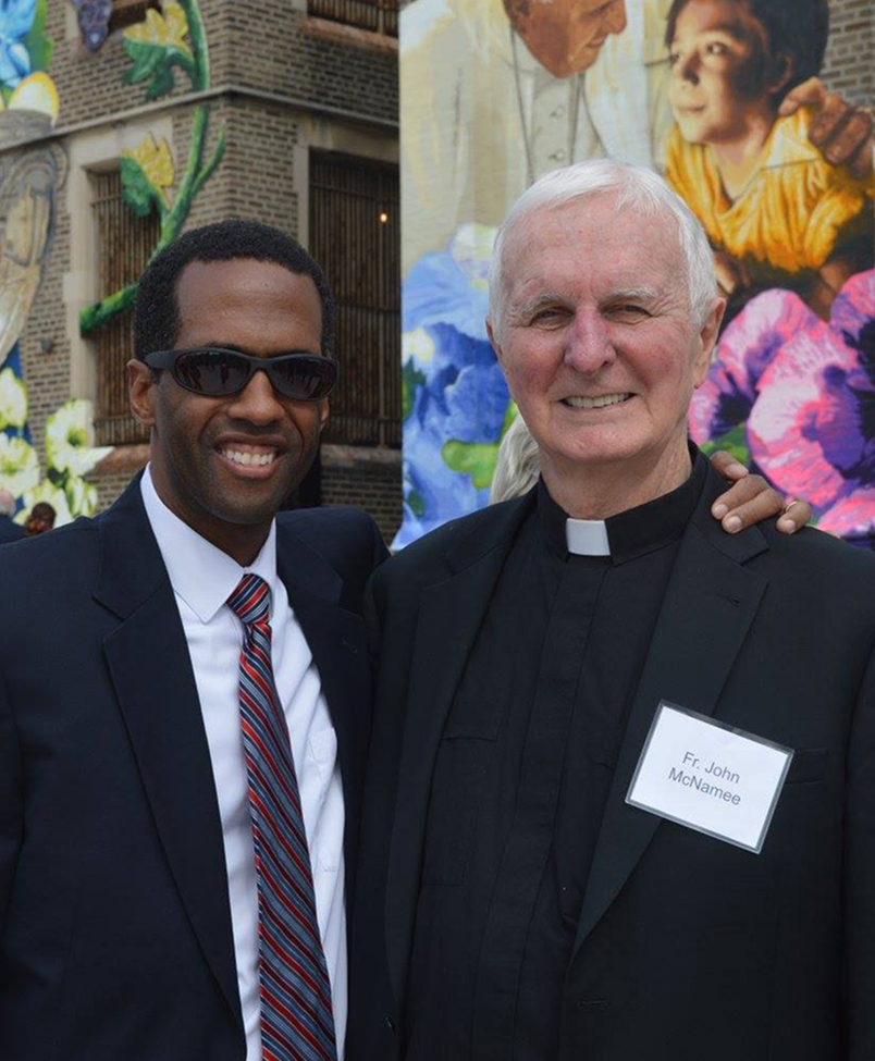 Two gentlemen standing infront of St. Malachy building