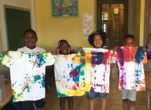Row of students showing their tie dye arts and crafts