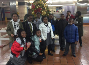 Students posing for a picture infront of a christmas tree