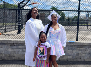 Graduated students posing for picture in front of St Malachy Catholic School courts